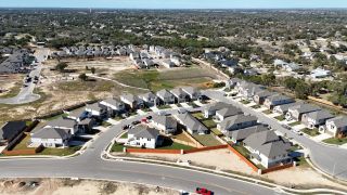 Street view Charming suburban neighborhood layout in Lariat 45' by Perry Homes, Liberty Hill, TX, showcasing modern development.