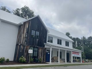 Street view A modern barn-style building with rustic wood accents in Hayes Park by New Leaf Builders (Johns Island, SC).