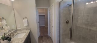 A sleek bathroom with a granite countertop, modern sink, glass shower, and neutral tones for a minimalist vibe.