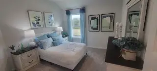 A cozy bedroom with elegant blue accents, artistic decor, and soft lighting, creating a serene and inviting atmosphere.