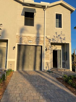 Street view A modern two-story home with elegant stone accents in Highland Oaks by D.R. Horton (Pompano Beach, FL).