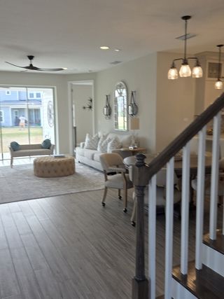 Model Home A modern living area with sleek flooring, cozy seating, elegant lighting, and open layout, perfect for casual gatherings.