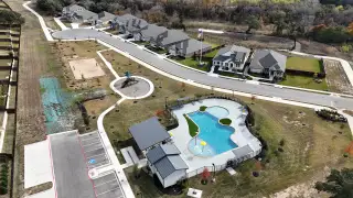 Community Amenities Aerial view of Riverview's vibrant community with a beautiful pool and recreational spaces by Brightland Homes (Georgetown, TX).