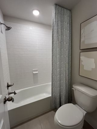 A bathroom featuring a soaking tub, glass-enclosed shower, and neutral decor.