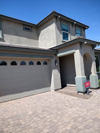 Elegant stucco home with a tiled roof and charming porch in Paradisi Discovery Collection by Taylor Morrison (Surprise, AZ).