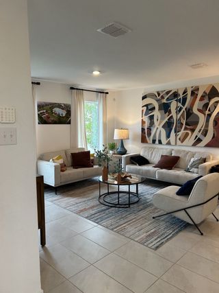 A stylish living room with neutral tones, artistic decor, and natural light.