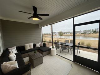 A cozy screened porch with modern seating, dining area, and serene lake views. Ideal for relaxation and entertaining.