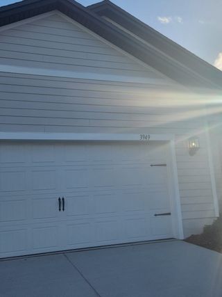 A modern white garage in Jennings Farm by LGI Homes, Middleburg, FL, featuring sleek lines and a well-lit exterior.