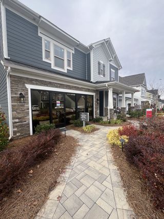 A modern two-story home with stone accents and landscaped front in Stafford at Langtree by Taylor Morrison (Mooresville, NC).
