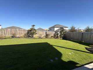 Model Home A well-maintained backyard with a privacy fence, fresh landscaping, and plenty of open space.