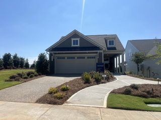 A charming gray home with a neat lawn and inviting driveway in Carolina Riverside by Del Webb (Belmont, NC).
