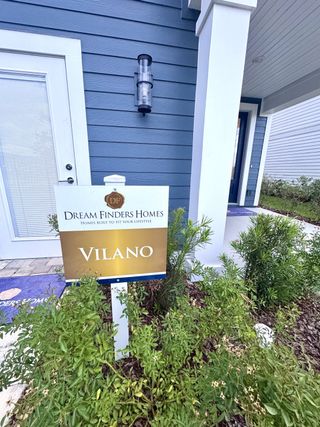 Elegant blue siding and a cozy porch in Brook Forest by Dream Finders Homes (St. Augustine, FL).