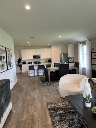 A modern open-concept living space with cozy seating, sleek kitchen, and stylish decor.