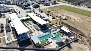 Community Amenities Aerial view of Easton Park's modern community center and pool area by Pacesetter Homes in Austin, TX, featuring sleek design.