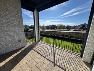 Model Home Spacious backyard with green grass and a private stone fence, perfect for outdoor relaxation and activities.