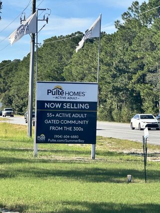 A welcoming entrance to Summer Bay at Grand Oaks by Pulte Homes in St. Augustine, FL, featuring a sales sign for the 55+ gated community.