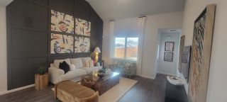 Model Home A contemporary living room featuring abstract wall art, a cozy beige sofa, and a rustic wood coffee table.