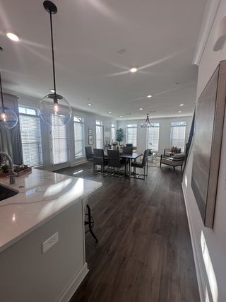 An open-concept living space with wood floors, large windows, and sleek pendant lighting, perfect for entertaining.