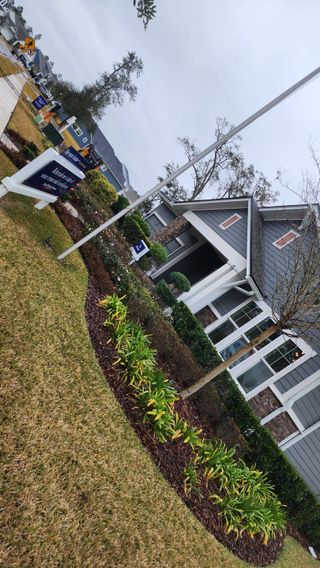 A charming craftsman-style home with stone accents and lush landscaping in Oak Grove at SilverLeaf by David Weekley Homes (St. Augustine, FL).