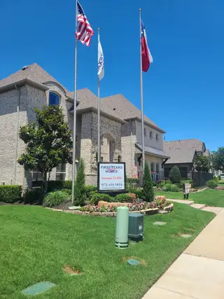 Elegant stone home with manicured lawn in Sutton Fields by First Texas Homes (Celina, TX).