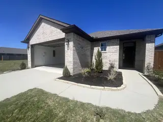 A modern brick home with a two-car garage, a paved walkway, and fresh landscaping in Towne Lake, built by Caldwell Homes in Cypress, TX.