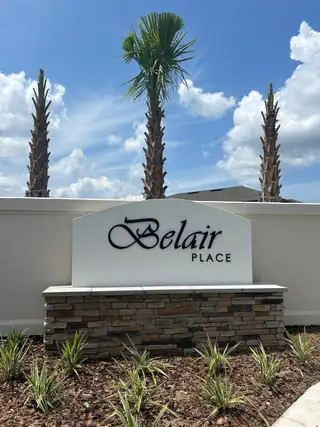 Street view A beautifully landscaped entrance with vibrant greenery at Belair Place by Starlight Homes (Sanford, FL).