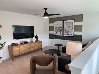 A modern living area with sleek decor, wall art, and a stylish media console under a mounted TV.