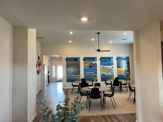 A contemporary meeting room with round tables, sleek chairs, and informative wall displays.