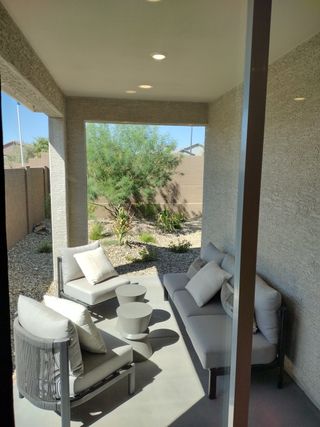 A cozy patio with modern gray seating, accent tables, and natural views, perfect for relaxation in the serene outdoors.