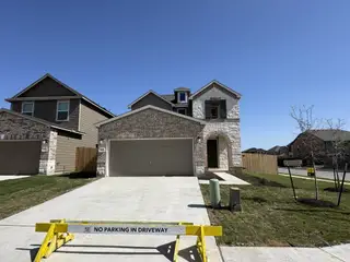 Street view A lovely brick home with modern design in Presidential Meadows by KB Home (Manor, TX).
