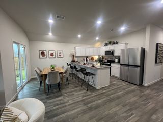 Model Home A spacious kitchen and dining area featuring sleek countertops, modern appliances, and elegant decor.
