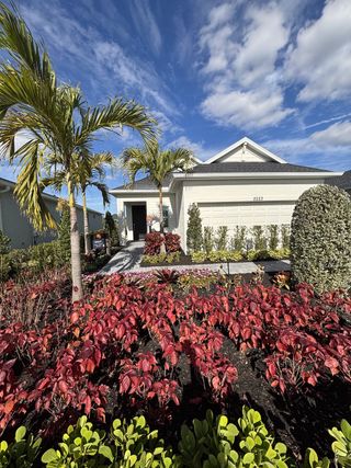 Street view A stunning landscaped home with vibrant foliage and palm trees in The Timbers at Everlands by Lennar (Palm Bay, FL).