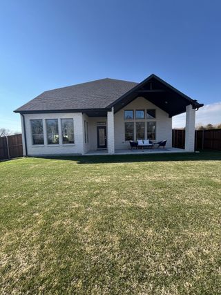 A charming white brick home with a spacious backyard in Cross Creek Meadows by Trophy Signature Homes (Celina, TX).