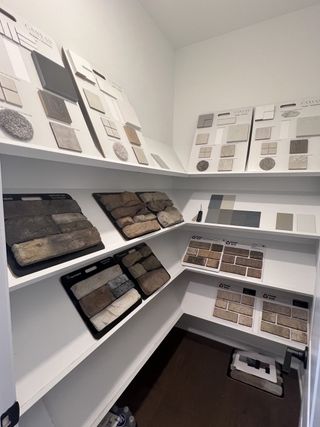 A well-organized design room with various tile and stone samples displayed on shelves.