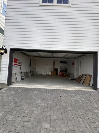 A spacious modern garage with white siding in Timbergrove Green by InTown Homes (Houston, TX).