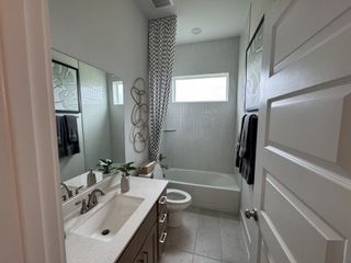 A sleek bathroom with modern fixtures, a white vanity, and stylish decor featuring geometric accents and a large wall mirror.