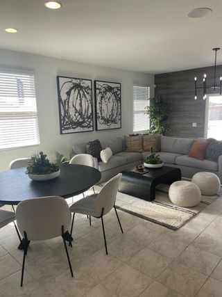 Model Home A modern living-dining space featuring a cozy sectional, abstract art, and a sleek round table.