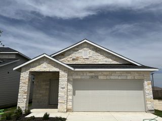 Street view A charming stone-front home with a two-car garage in Sonterra by CastleRock Communities (Jarrell, TX).