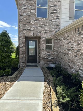 Charming brick exterior with landscaped walkway in Bauer Meadow by KB Home, Hockley, TX.