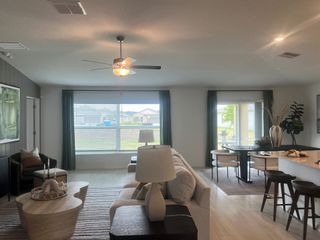 A contemporary living and dining area with large windows, cozy seating, and elegant decor.