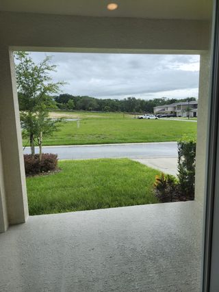 A charming view of lush greenery from a covered patio in Windrose by D.R. Horton, Apopka, FL.