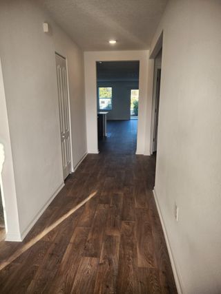 Model Home A sleek hallway with wood-look flooring and an open-concept design in Copes Landing by D.R. Horton (Jacksonville, FL).