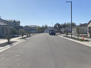 A modern street scene with new homes and tidy landscaping in Stonefield by Homes by Towne (Surprise, AZ).