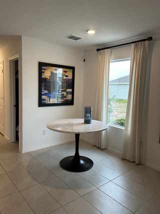 Model Home A bright dining nook with a marble-top table and large window.