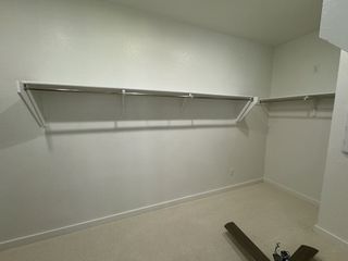 A spacious walk-in closet with ample hanging space and shelving, perfect for organized storage and wardrobe essentials.