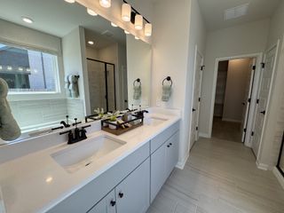 A modern bathroom with a sleek double vanity, elegant lighting, and a spacious walk-in shower.