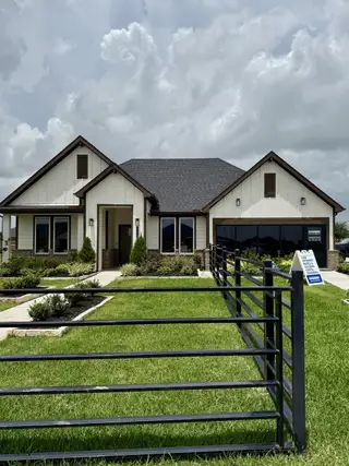 A charming modern home with a manicured lawn in Tamarron by D.R. Horton (Fulshear, TX).