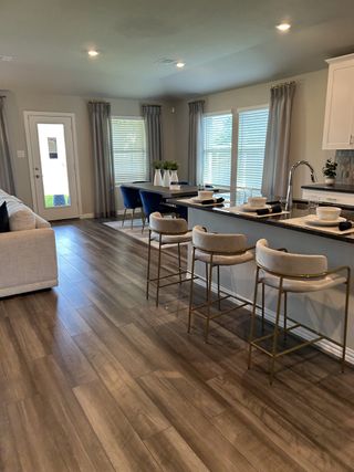 An open-concept kitchen and dining area with large windows, stylish decor, and ample space for gatherings.