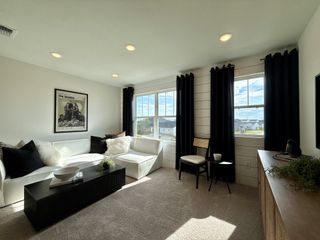A cozy living room with a white sectional sofa, dark curtains, and a chic black coffee table, perfect for relaxation.