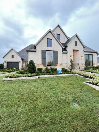 Elegant white brick home with tall windows and manicured lawn in Somerset Park 80' by Perry Homes (Rockwall, TX).